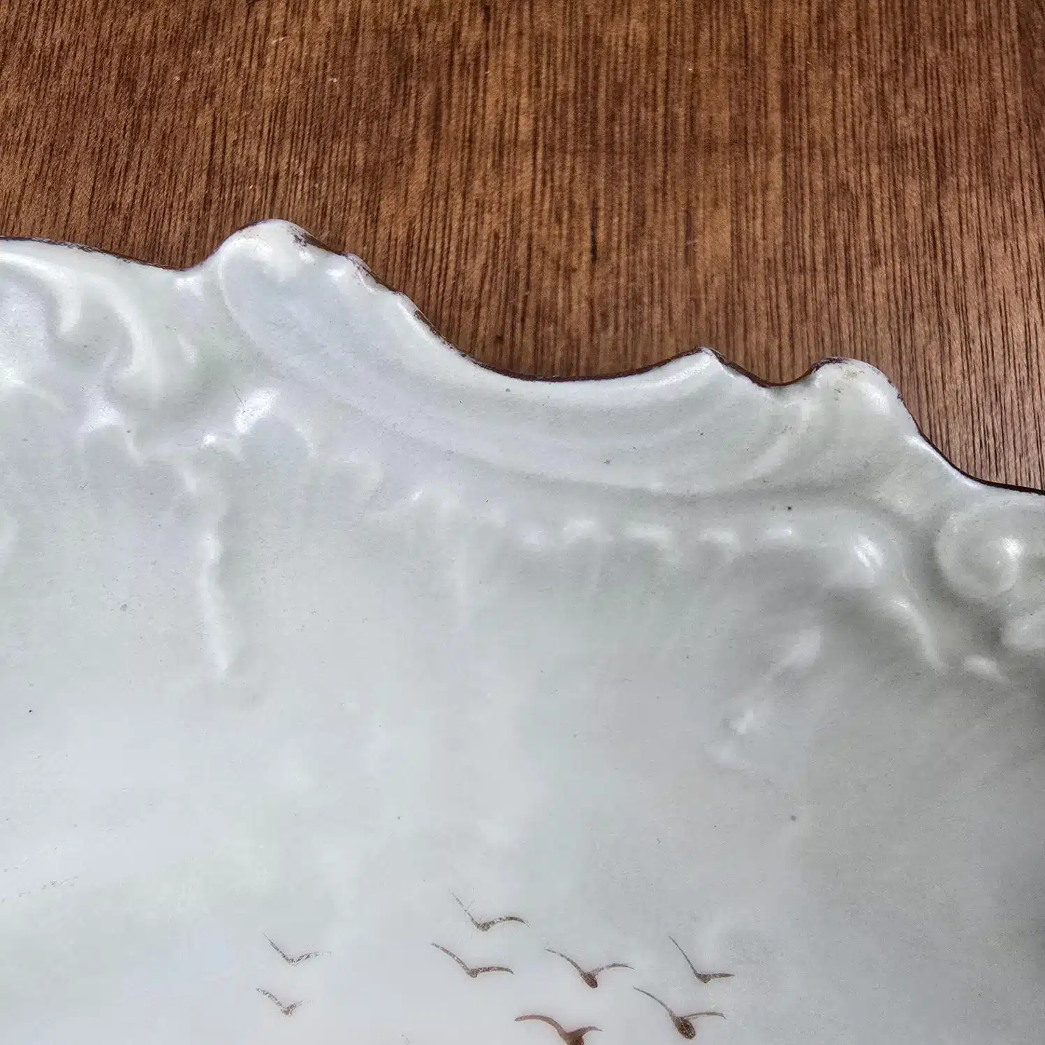 Assiette décorative ancienne Limoges – Scène champêtre peinte main, zoom sur le bord et le décor d'oiseaux dans le ciel