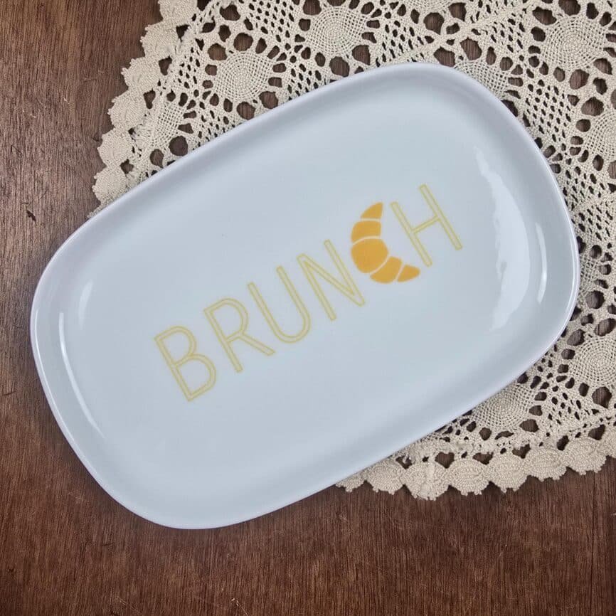 Assiette rectangulaire Luminarc BRUNCH – Porcelaine blanche et inscription jaune vue de dessus sur table en bois et napperons