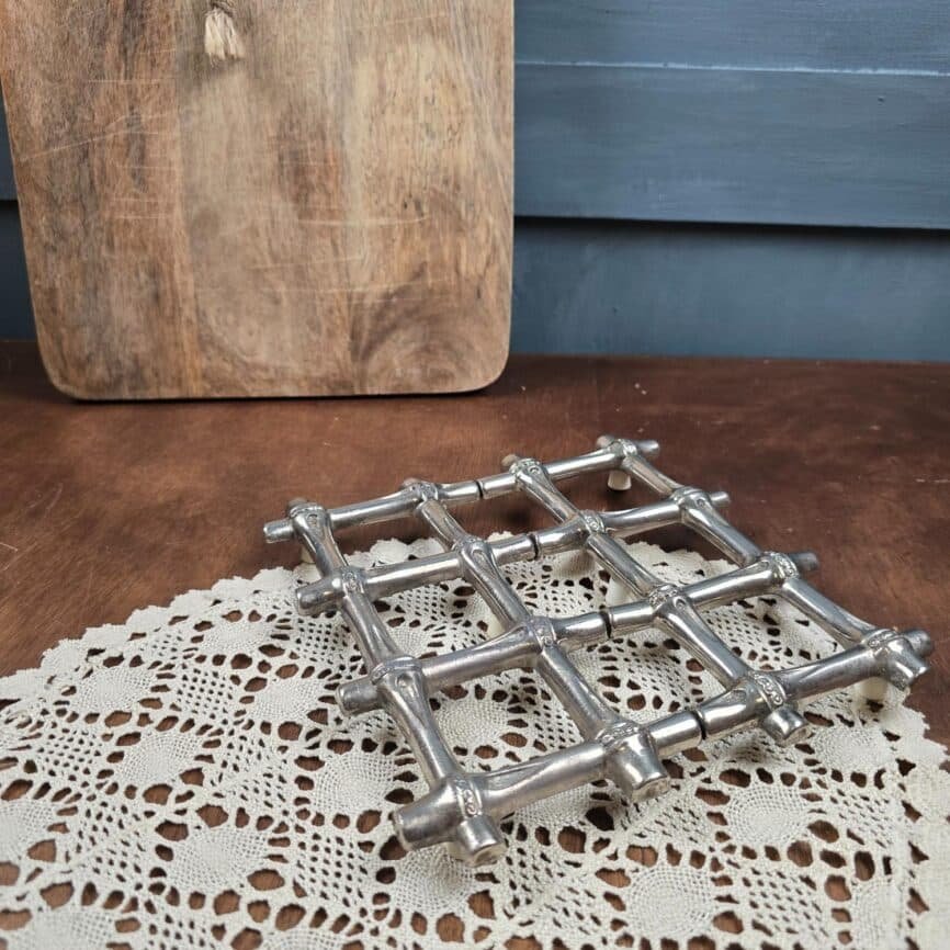 Dessous de plat extensible vintage en métal argenté – Trivet rétro modulable sur table en bois