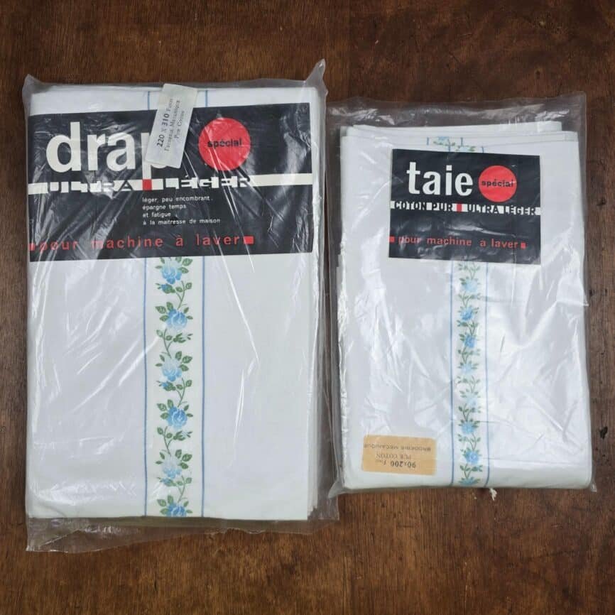 Ensemble drap plat 220x310 et taie traversin coton fleurs bleues vintage vue de dessus sur table en bois, neuf