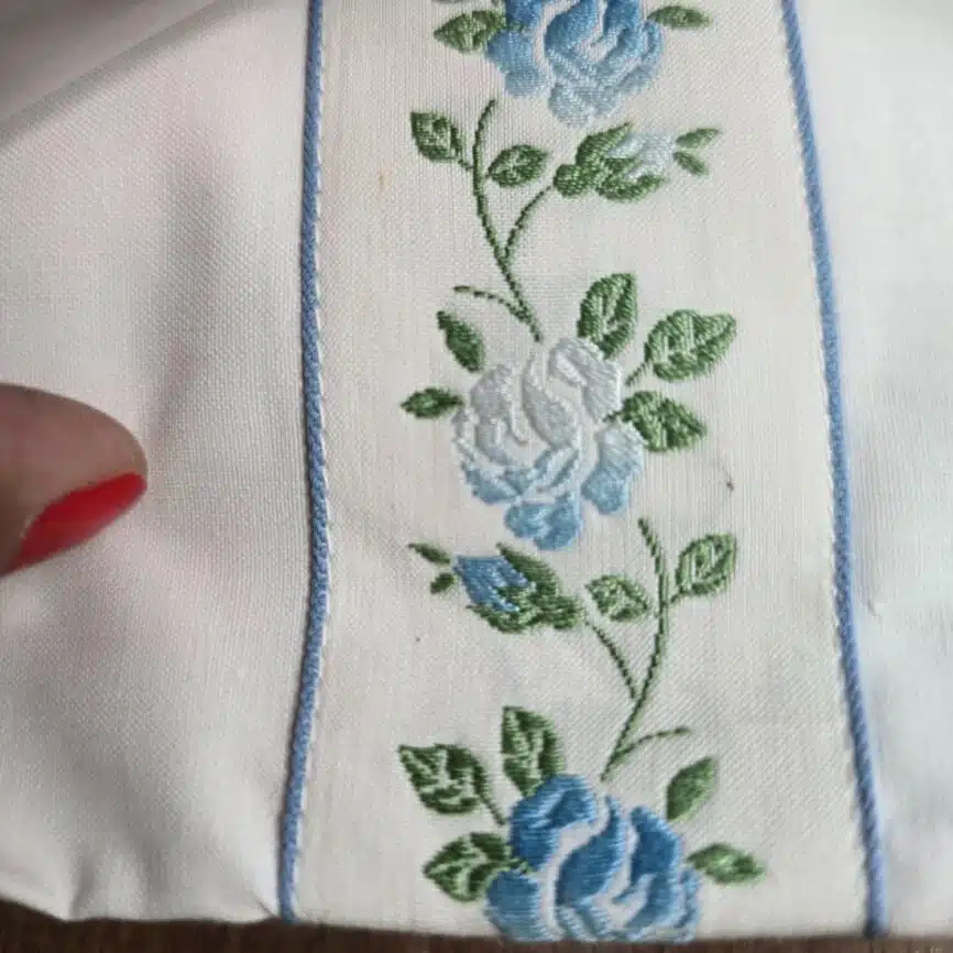 Ensemble drap plat et taie traversin coton fleurs bleues vintage, zoom sur le textile et la broderie