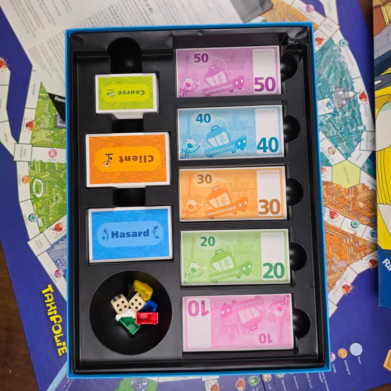 Jeu de société TaxiFolie Ravensburger 2006 complet, intérieur de la boîte avec billets, cartes, dés et pions