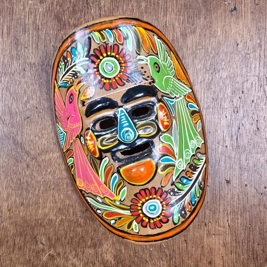 Masque mexicain en terre cuite peint à la main sur table en bois