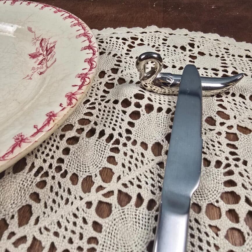 Repose-couteaux forme cygne en métal argenté vintage, avec couteau vue de trois quart