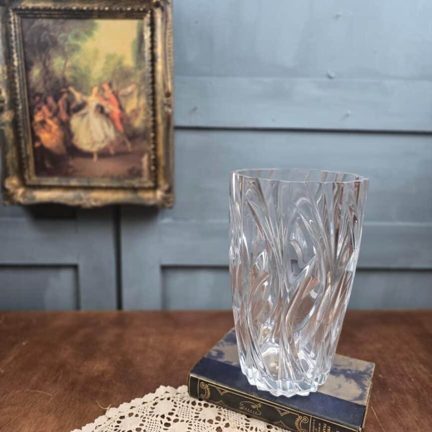 Grand vase vintage en verre moulé transparent, posé sur ancien livre, vide
