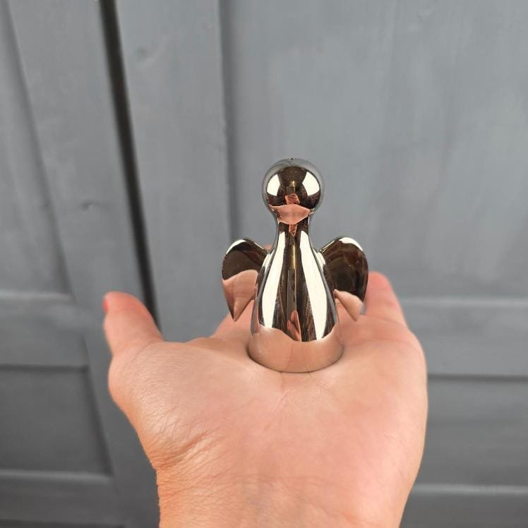 Salière ange Philippi Joyas Design en métal argenté tenu en main pour mesure