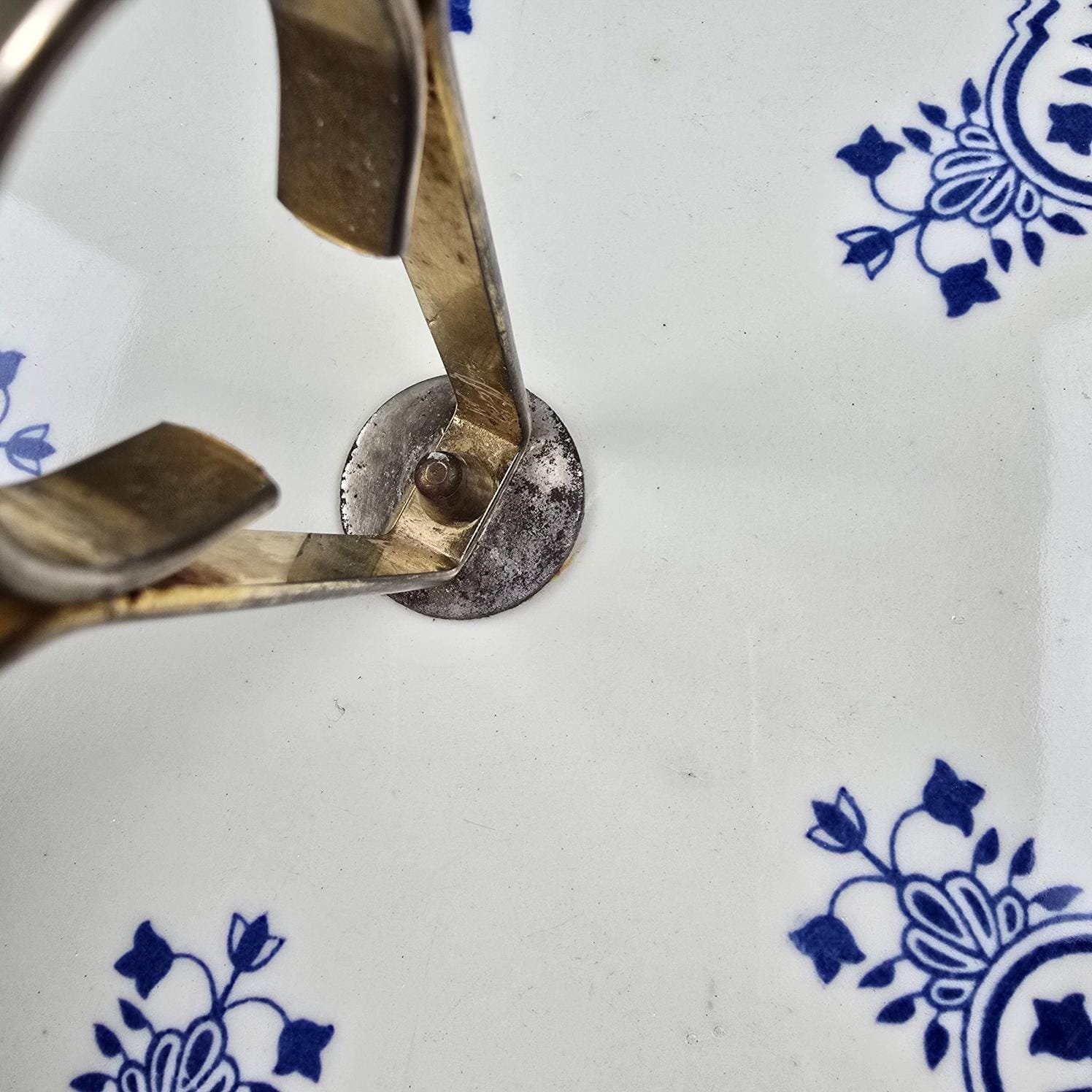 Plateau à fromage Gien vintage motif blanc et bleu, vue rapprochée de la hanse en métal