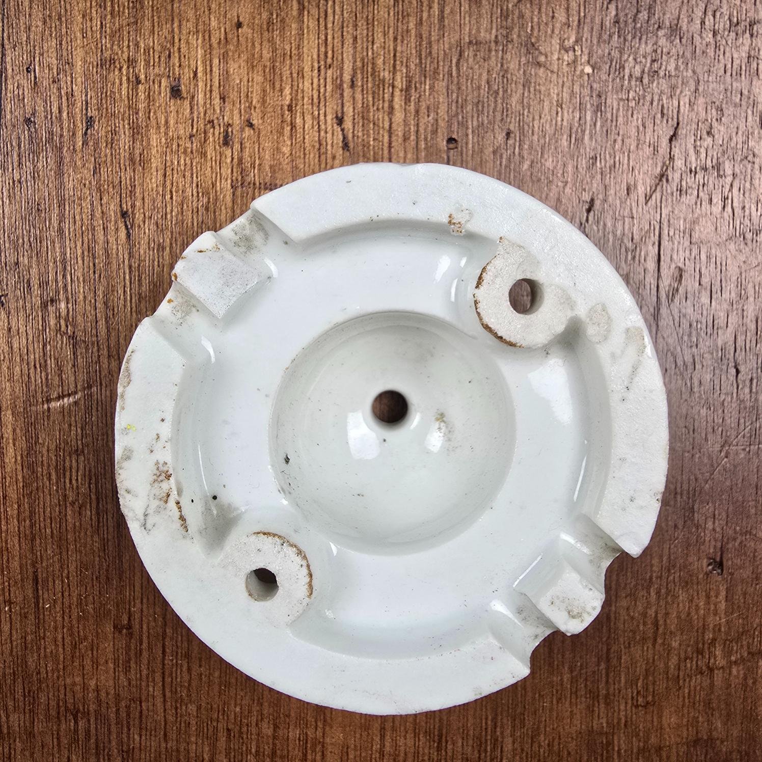 Rosace de plafond ancienne en porcelaine blanche, vue de dessous sur table en bois