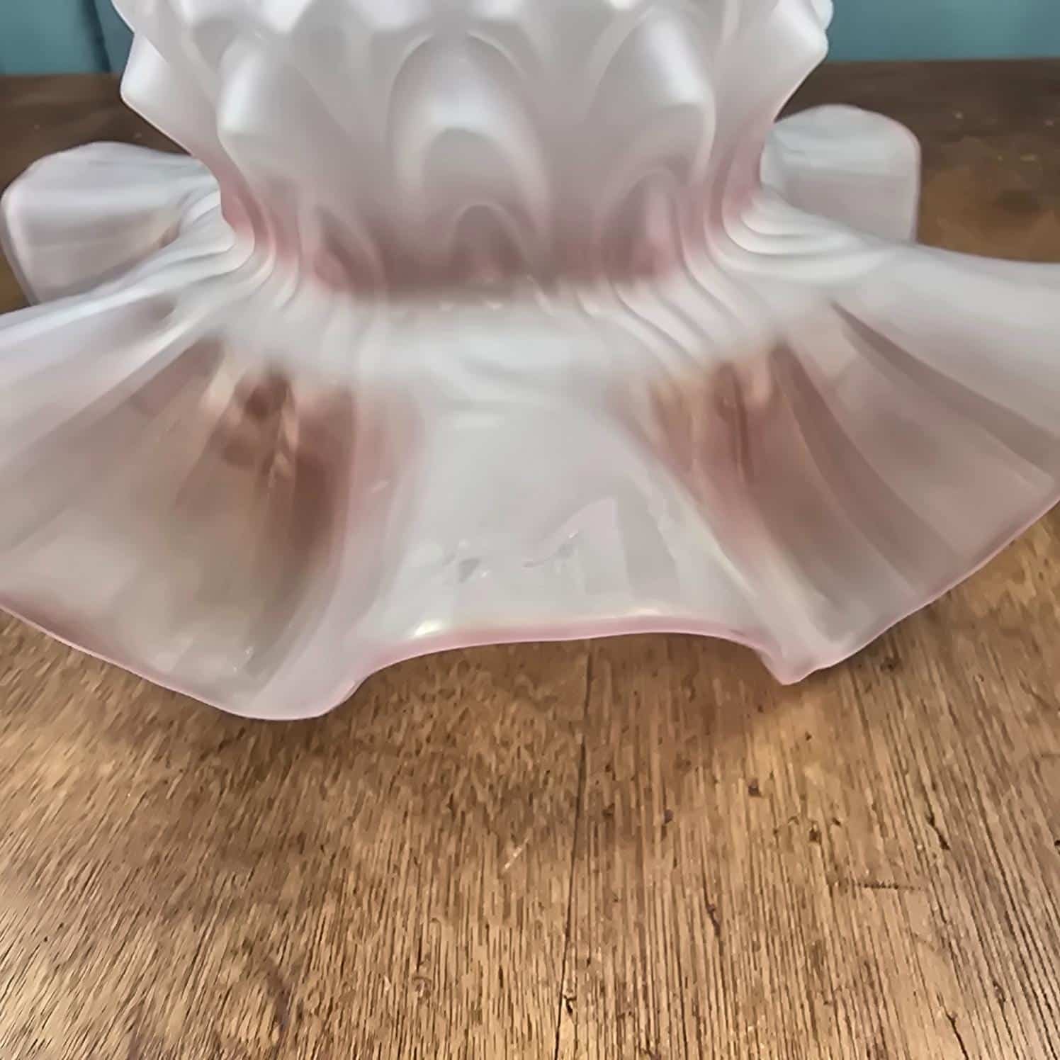 Abat-jour ancien en verre rose satiné, vue rapproché sur le bord ondulé