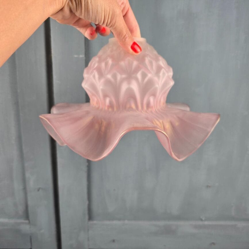 Abat-jour ancien en verre rose satiné, bord ondulé, tenu en main pour montrer le rendu suspendu