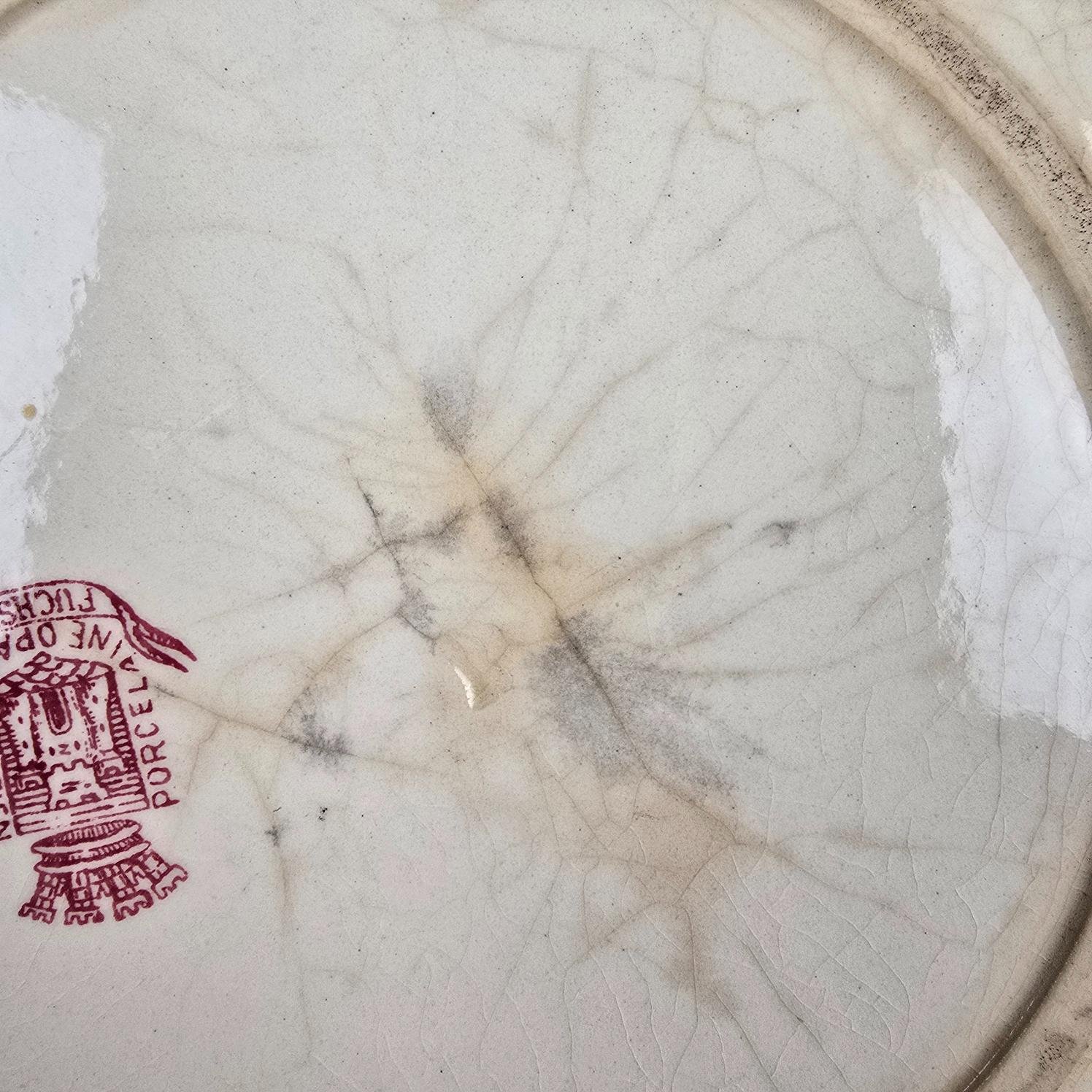 Dos d'une assiette anciennes Gien Fuchsia, Terre de fer fin XIXe montrant une fêlure