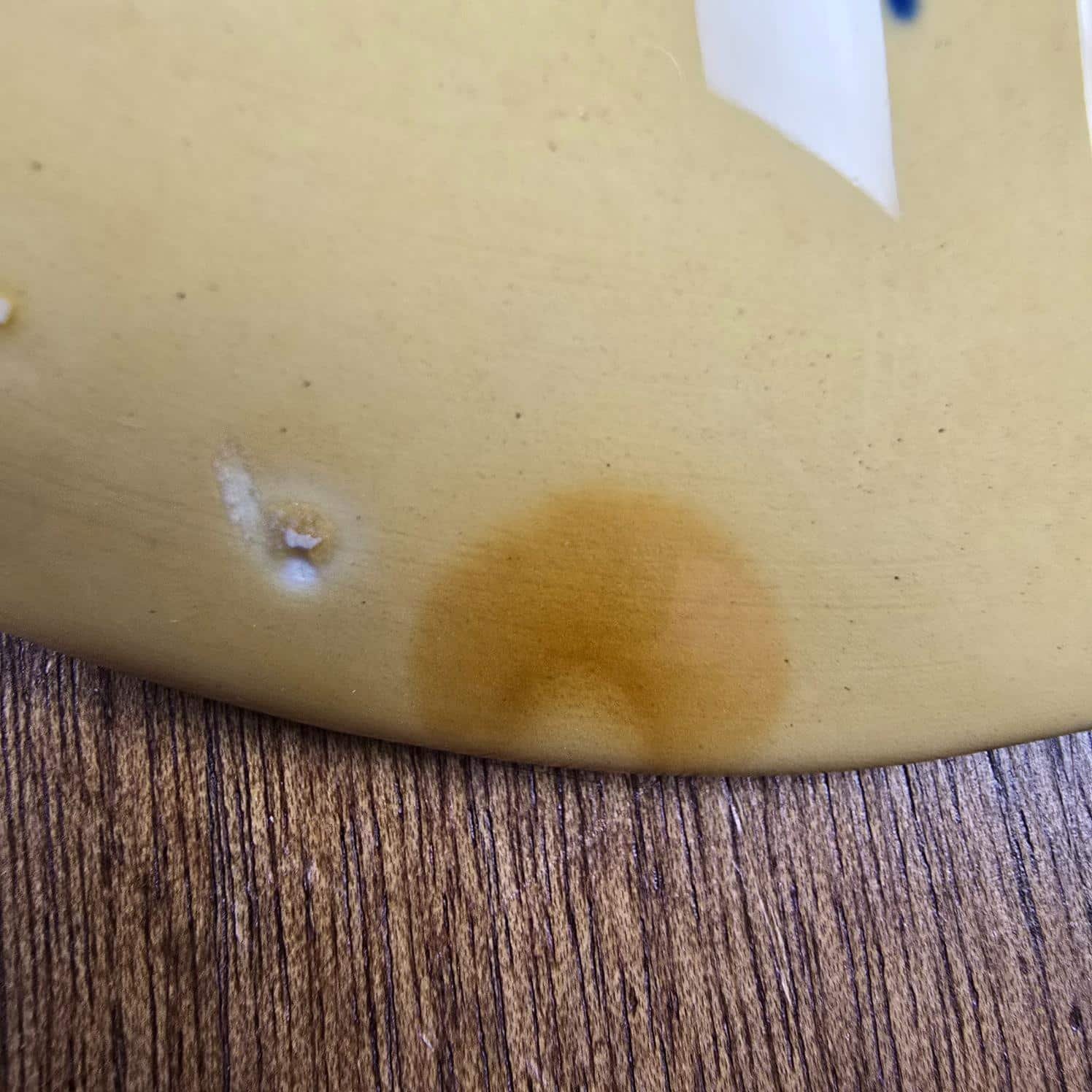 Assiette à huîtres Gien jaune ocre, vue rapprochée dune tâche jaune plus foncée au revers de l'assiette