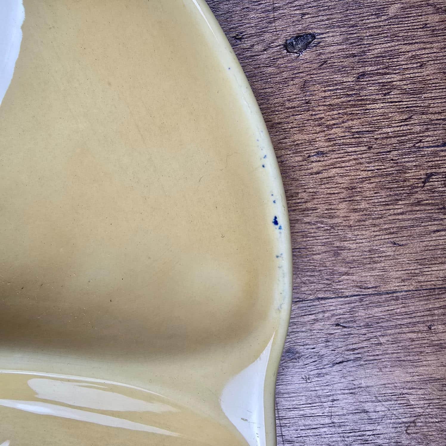 Assiette à huîtres Gien jaune ocre, zoom sur le défaut de pigment bleu