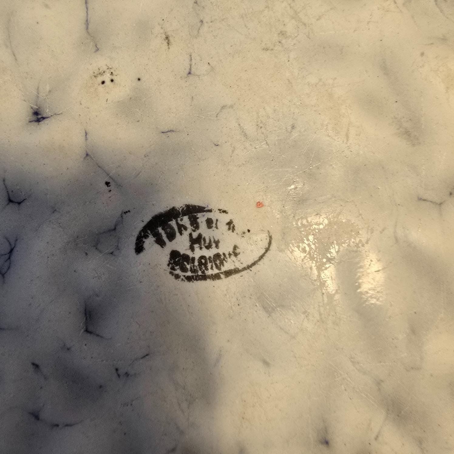 Bassin de lit ancien en tôle émaillée mouchetée, zoom sur l'estampille au dos du bassin