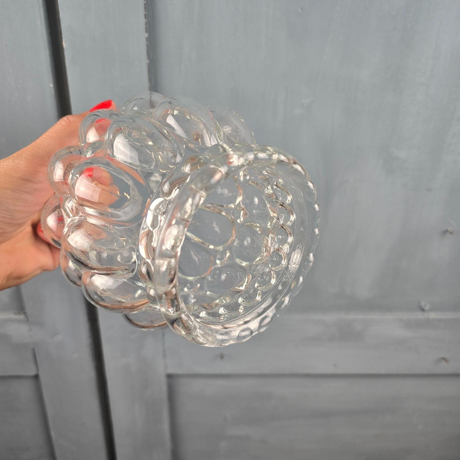 Globe en verre moulé transparent, Luminaire au décor bullé vintage, tenu en main, vue plongeante