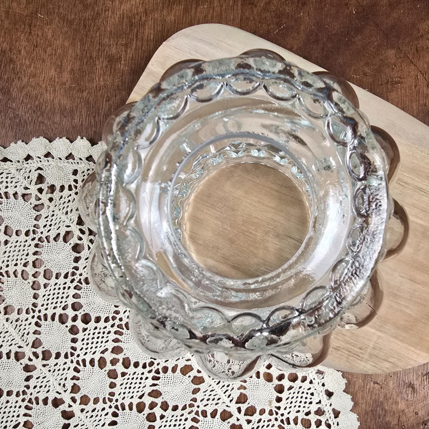 Globe en verre moulé transparent – Luminaire au décor bullé vintage vue de dessous sur table en bois et napperon