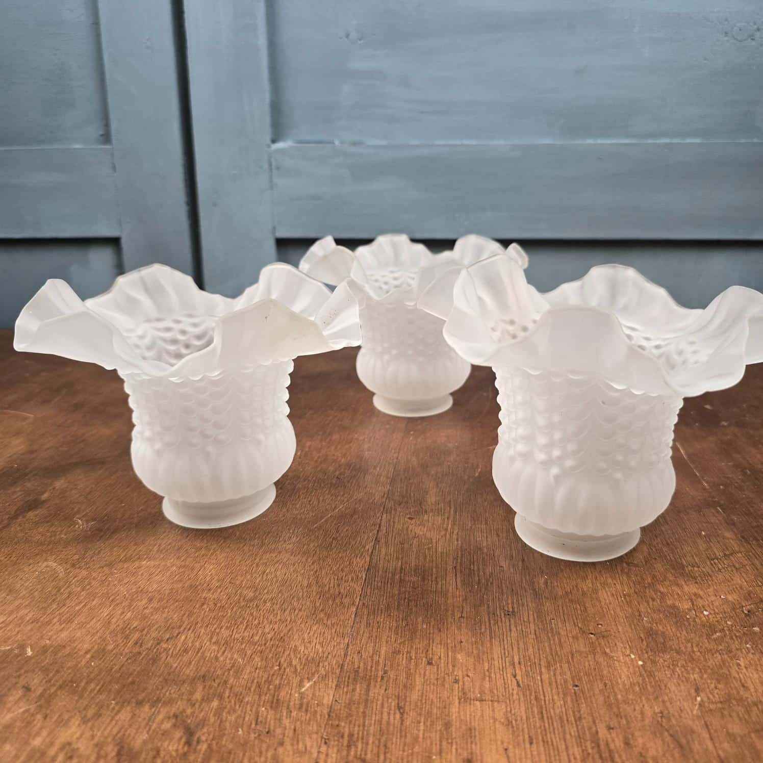 Lot de 3 tulipes anciennes en verre satiné pour luminaire posé à l'envers sur table en bois