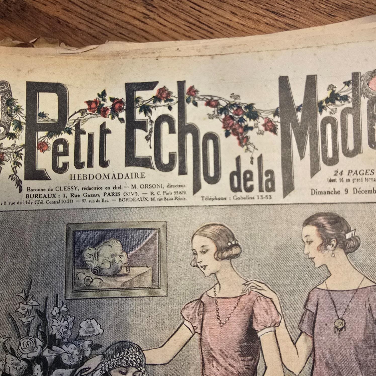 Vue rapprochée du titre de la couverture « Le Petit Écho de la Mode » avec ses jolies guirlandes de fleurs rouges
