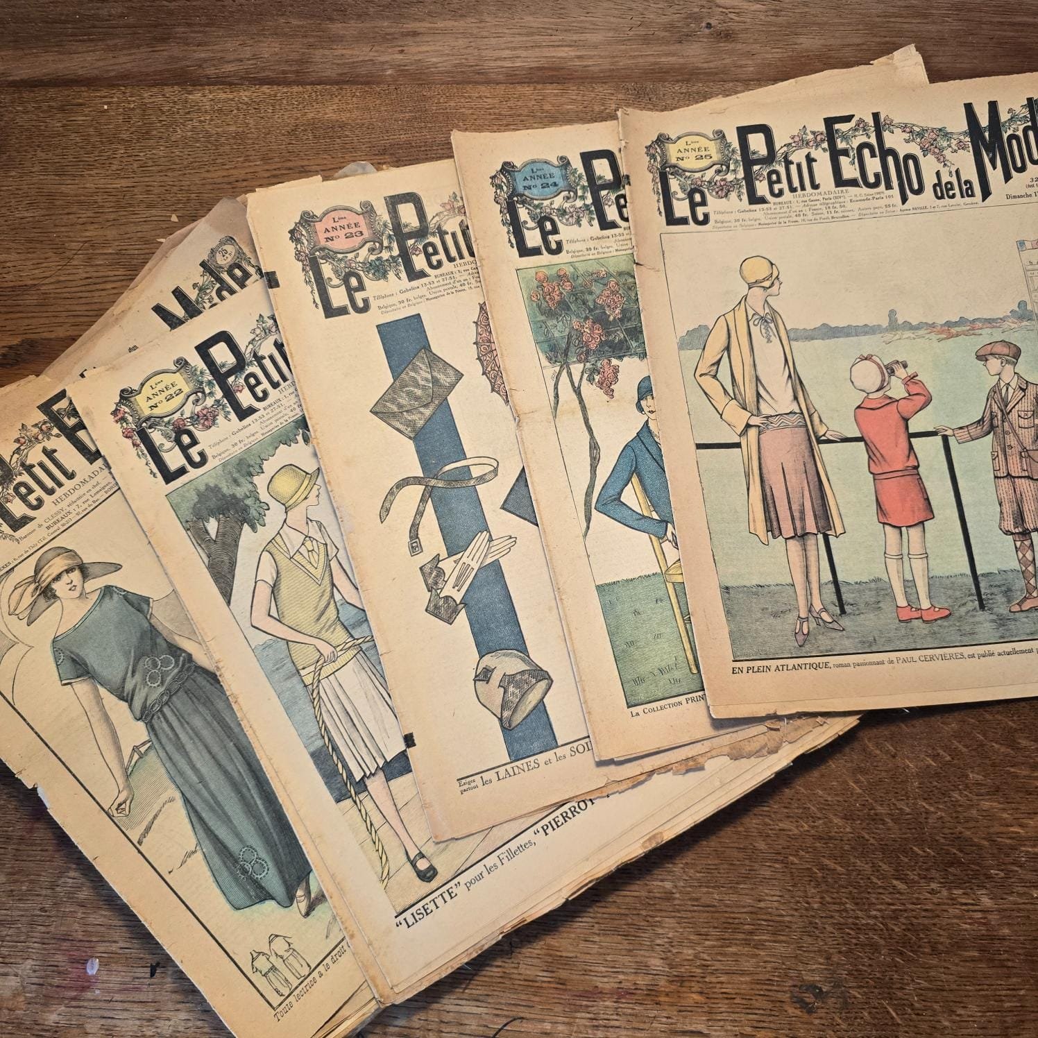 Magazines « Le Petit Écho de la Mode » de 1922, sur table en bois
