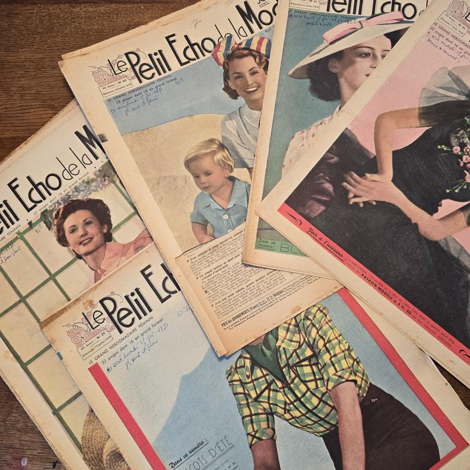 « Le Petit Écho de la Mode » de 1938, sur table en bois, mettant en avant les visages rayonnants des femmes sur les couvertures
