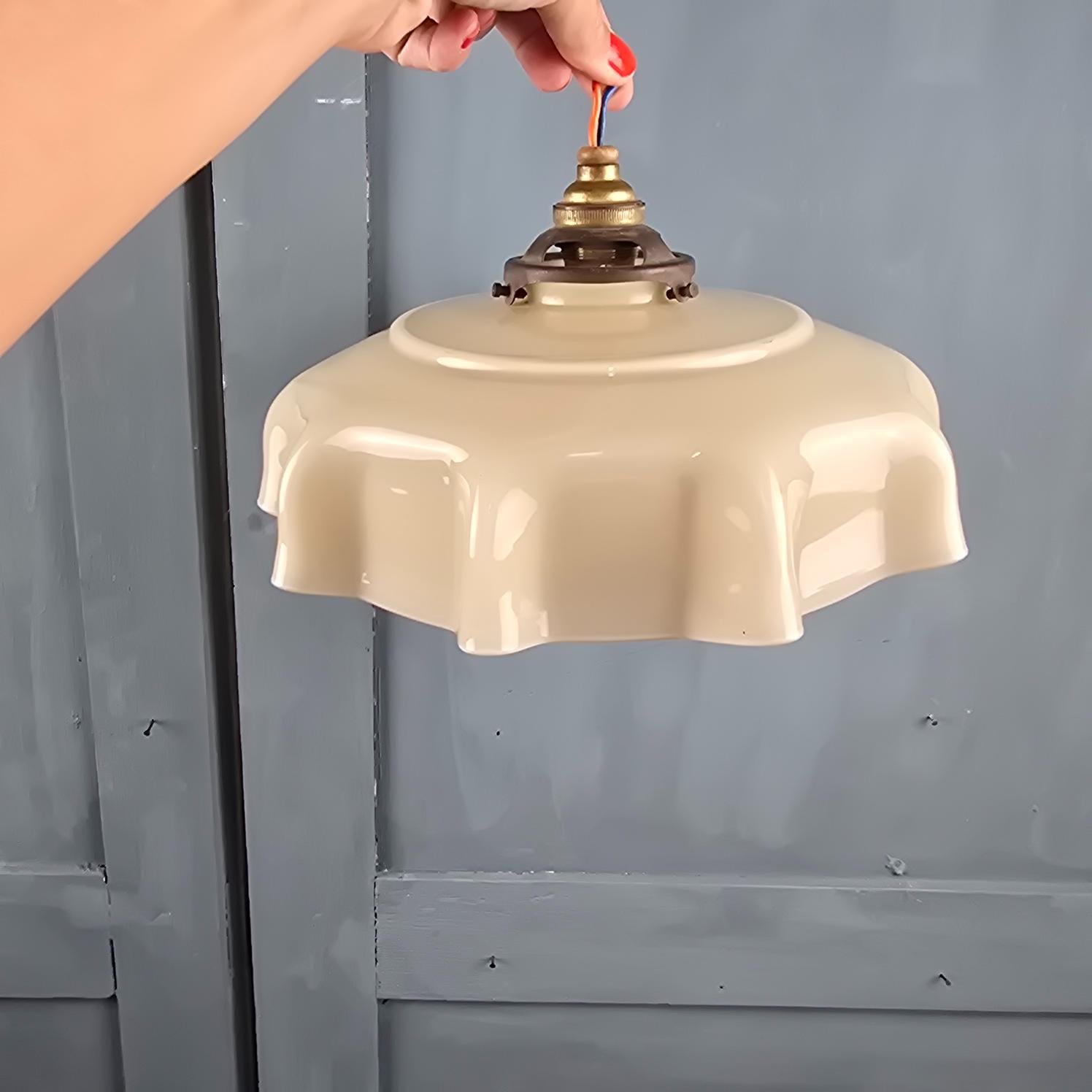 Suspension vintage en verre opalin beige, forme drapée, tenue en main par le câble pur illustrer le rendu une fois au plafond