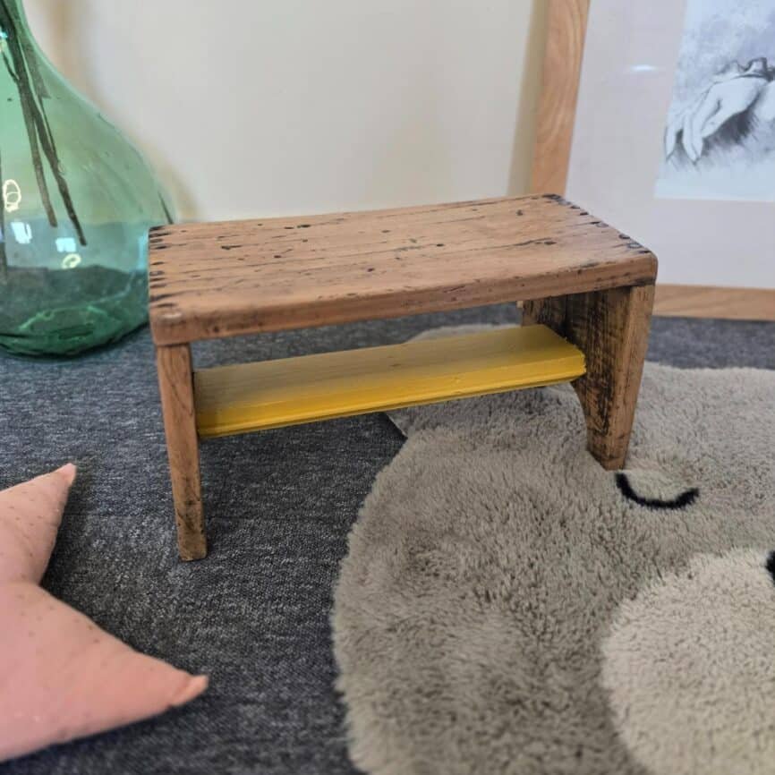 Petit tabouret ancien artisanal en bois rénové avec traverse jaune moutarde dans une ambiance enfantine