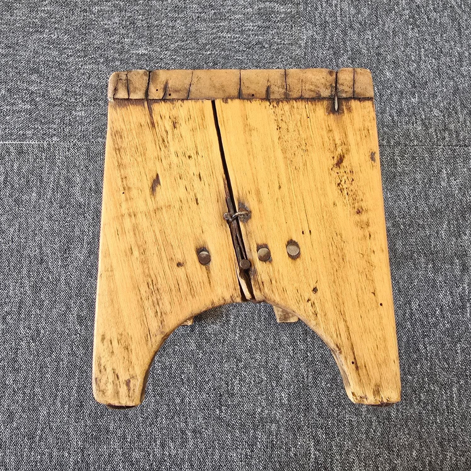 Petit tabouret ancien artisanal en bois, vue de côté mettant en avant les nombreux clous