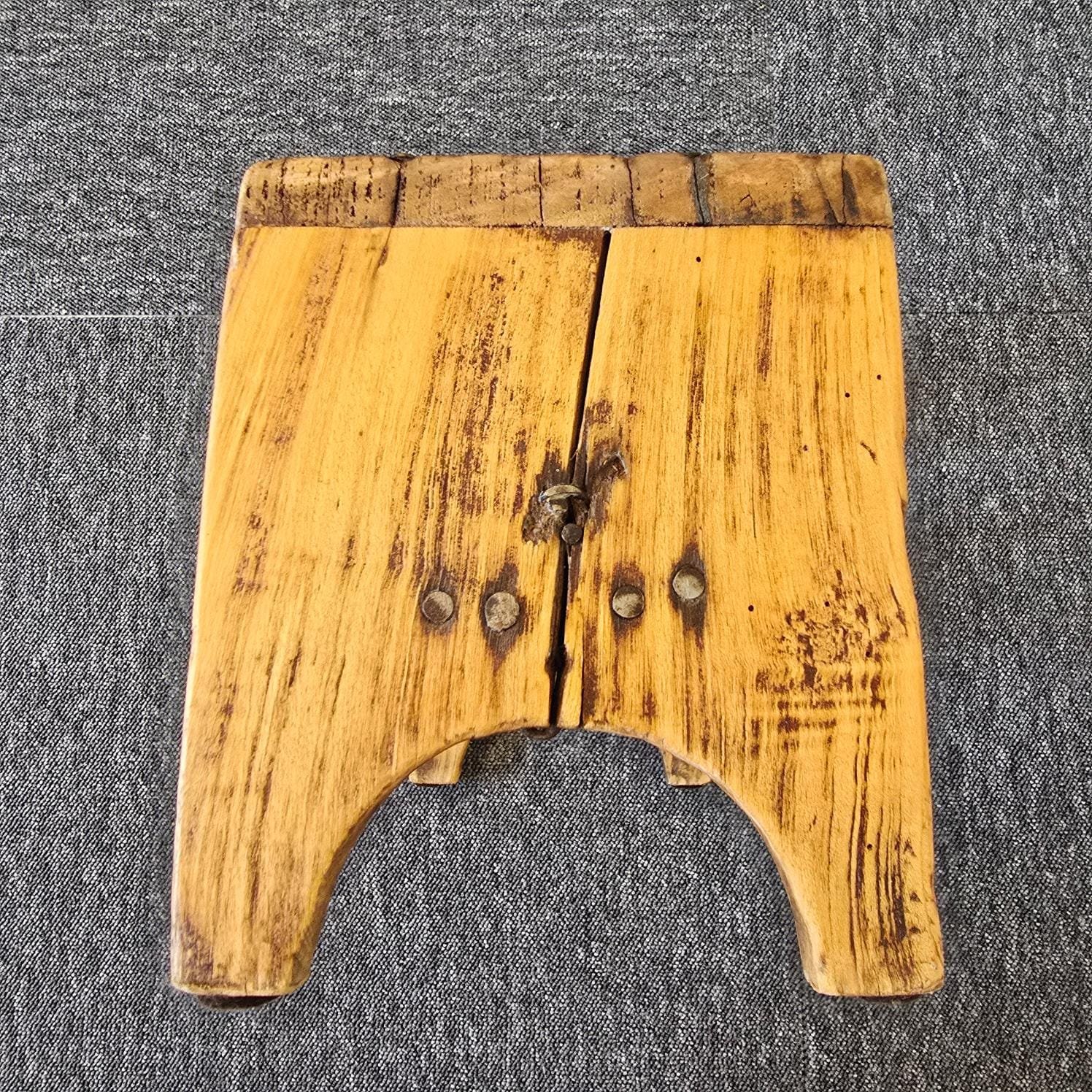 Petit tabouret ancien artisanal en bois, vue d'un autre côté pour montrer le bois fendu et réparé