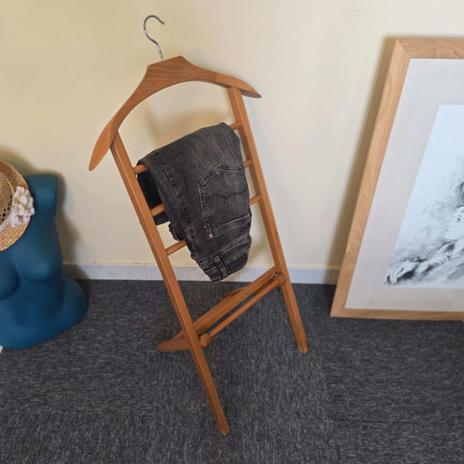 Valet de chambre vintage pliant en bois, mis en situation avec un pantalon
