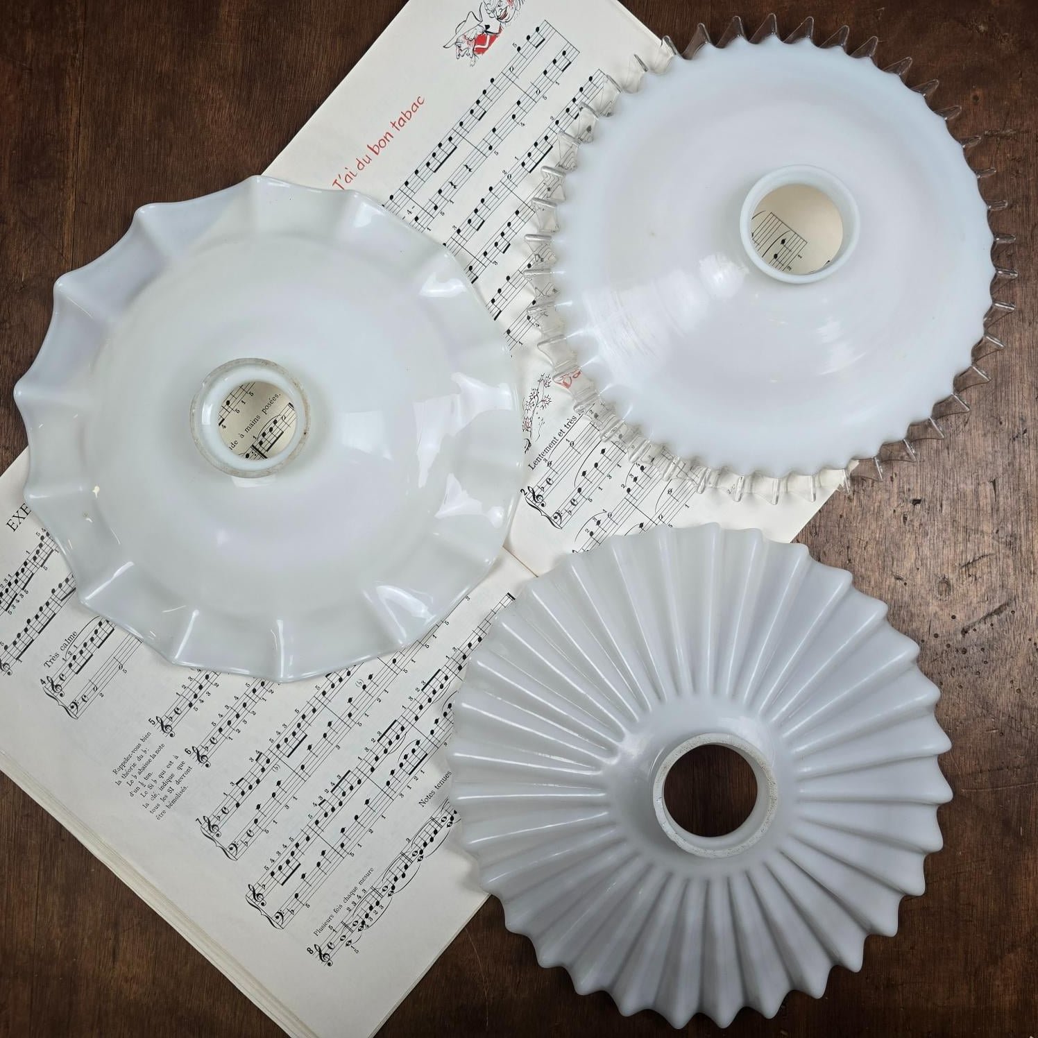 Trois abat-jour vintage en verre opalin blanc, modèles plissé, ondulé et festonné, vus du dessus