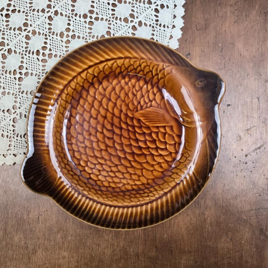 Assiette poisson Sarreguemines vintage en faïence caramel, vue de dessus sur bois