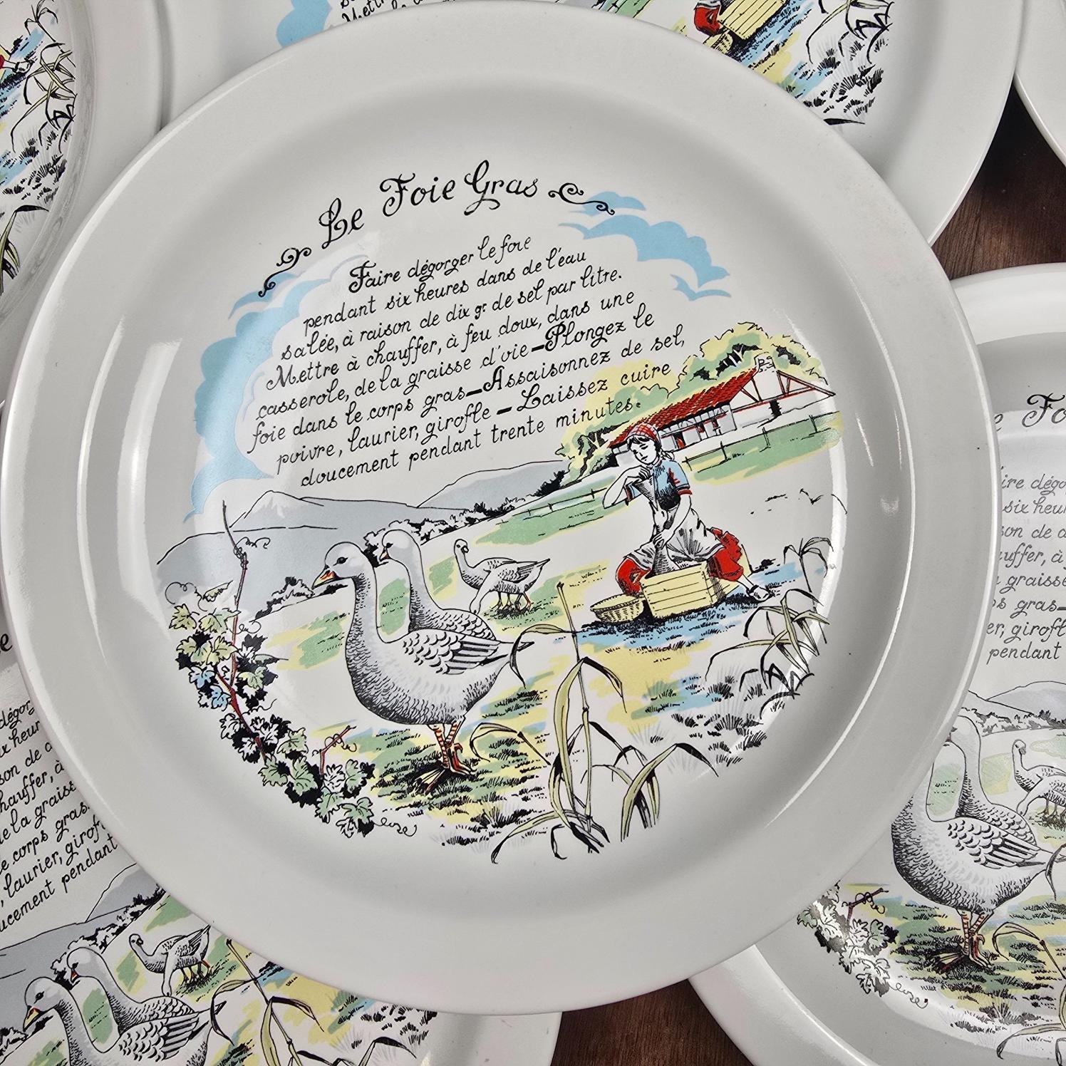 Assiette Revol à décor de recette de foie gras, présentée devant d'autres assiettes