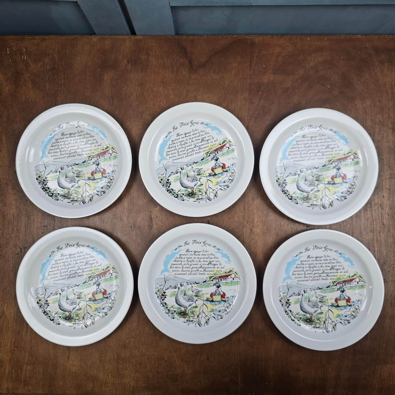 Six assiettes Revol à décor de recette de foie gras, disposées en deux rangées