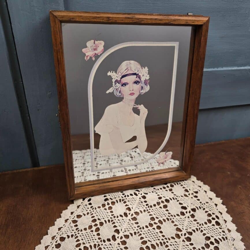 Boîte à clés murale vintage en bois avec miroir illustré d'une femme au style Art déco, vue de face