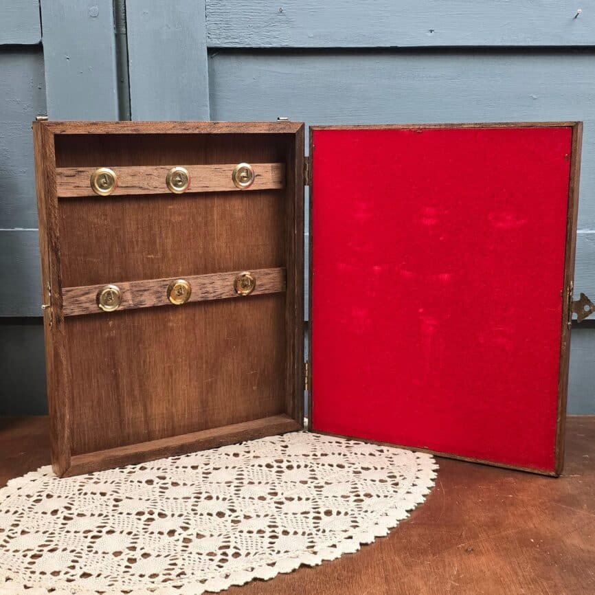 Boîte à clés murale vintage ouverte, six crochets à gauche et feutrine rouge à droite