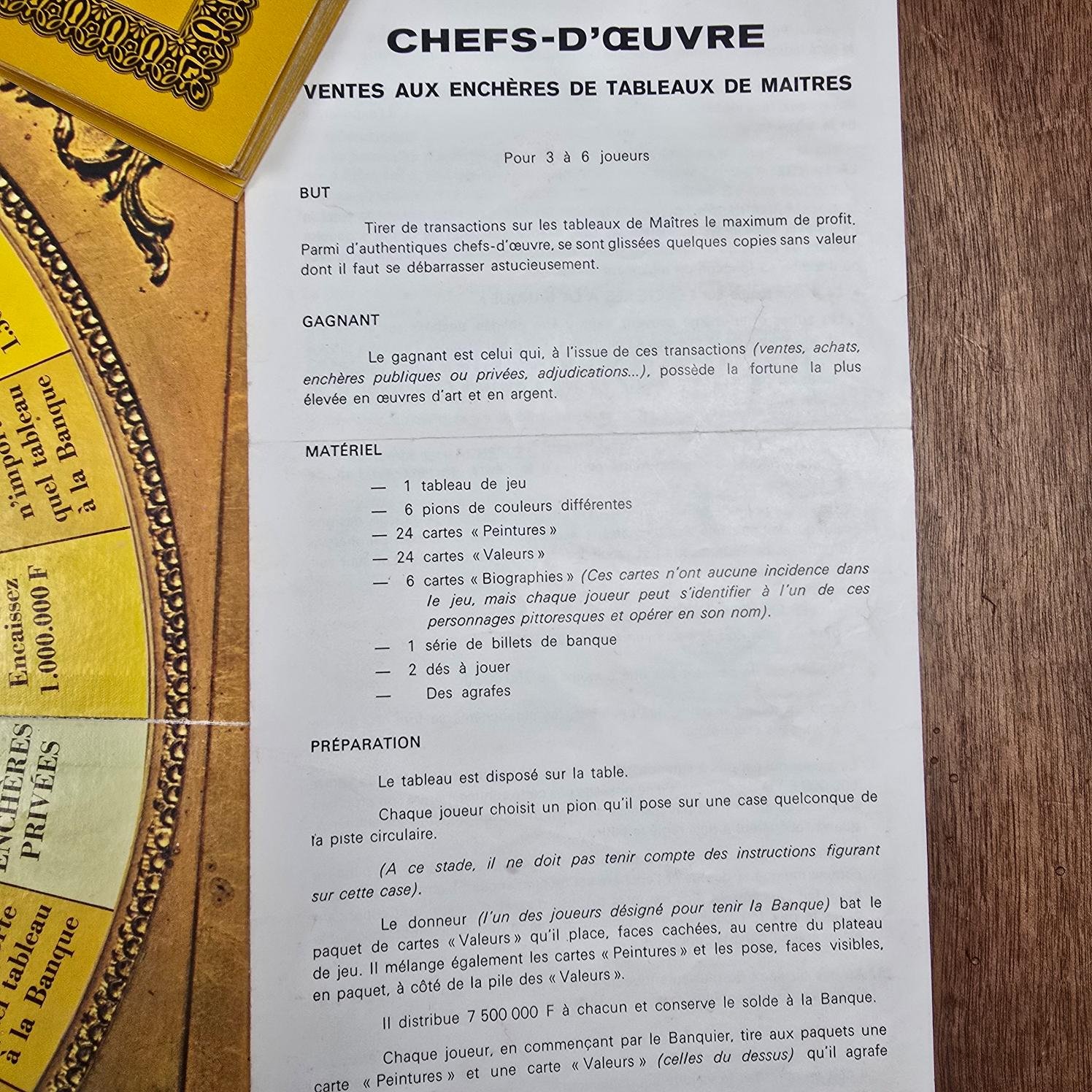 Feuillet de règles du jeu Chefs-d’œuvre posé à côté du plateau