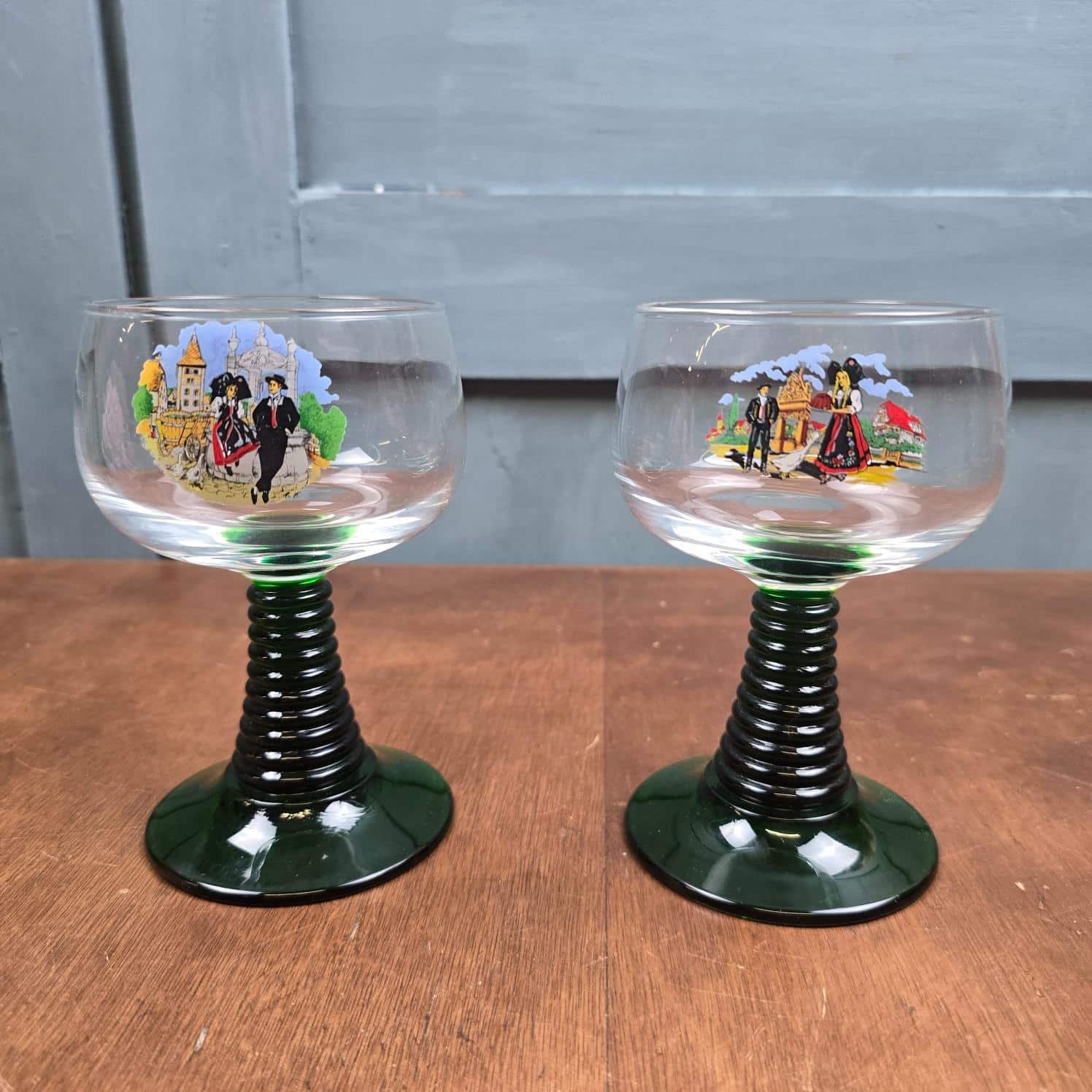 Deux verres à vin Luminarc à pieds verts torsadés, décors de costumes alsaciens