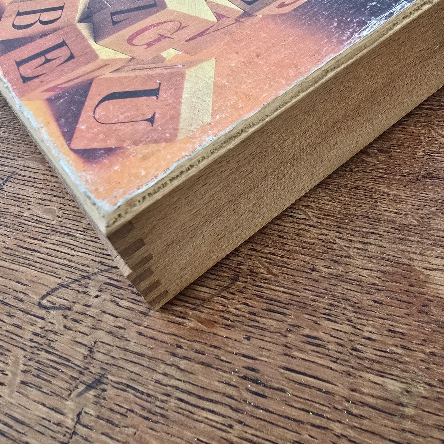 Détail du bord du coffret en bois Jeujura et de son couvercle illustré