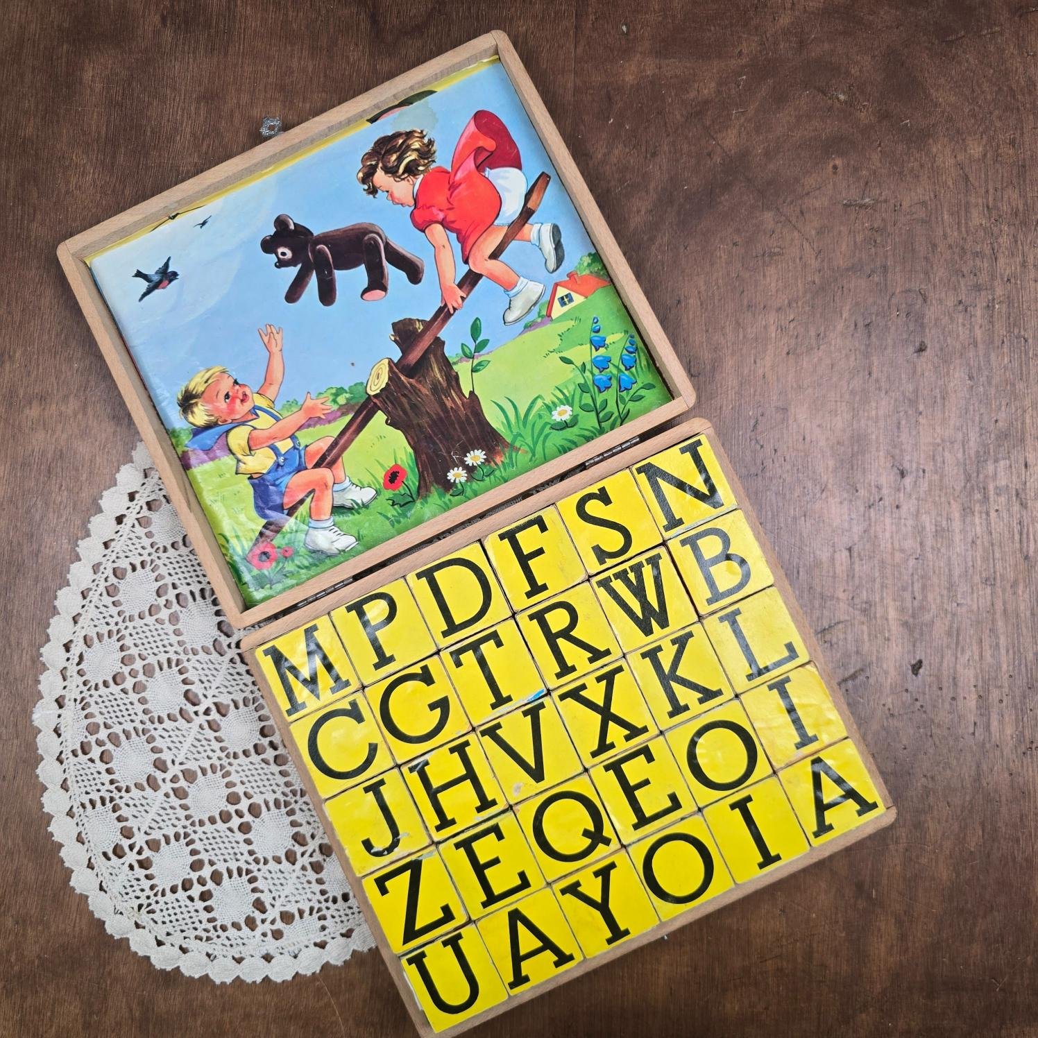 Puzzle de cubes en bois reconstituant une scène illustrée avec des enfants et un animal