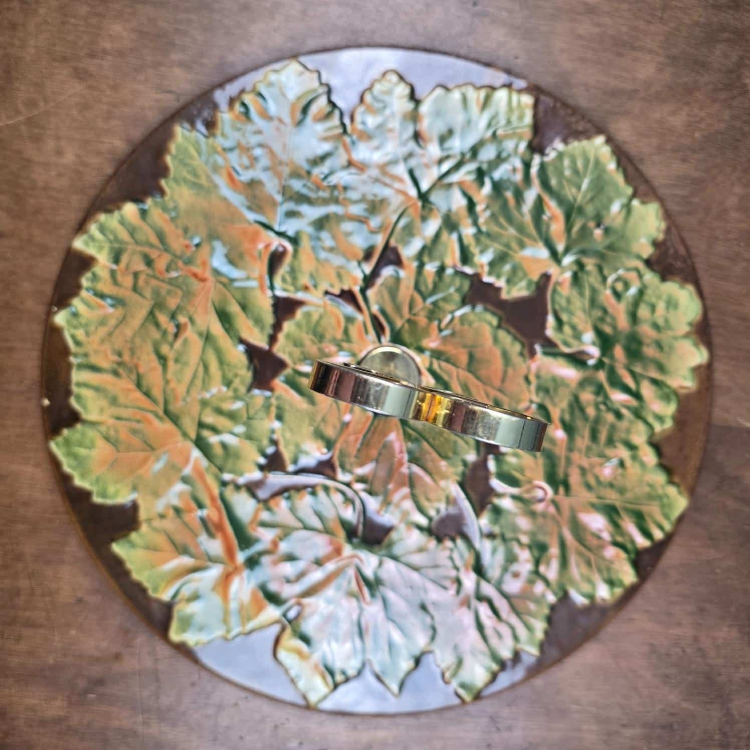 Vue de dessus du plateau à fromage Saint-Clément à décor de feuilles de vigne vertes et orangées