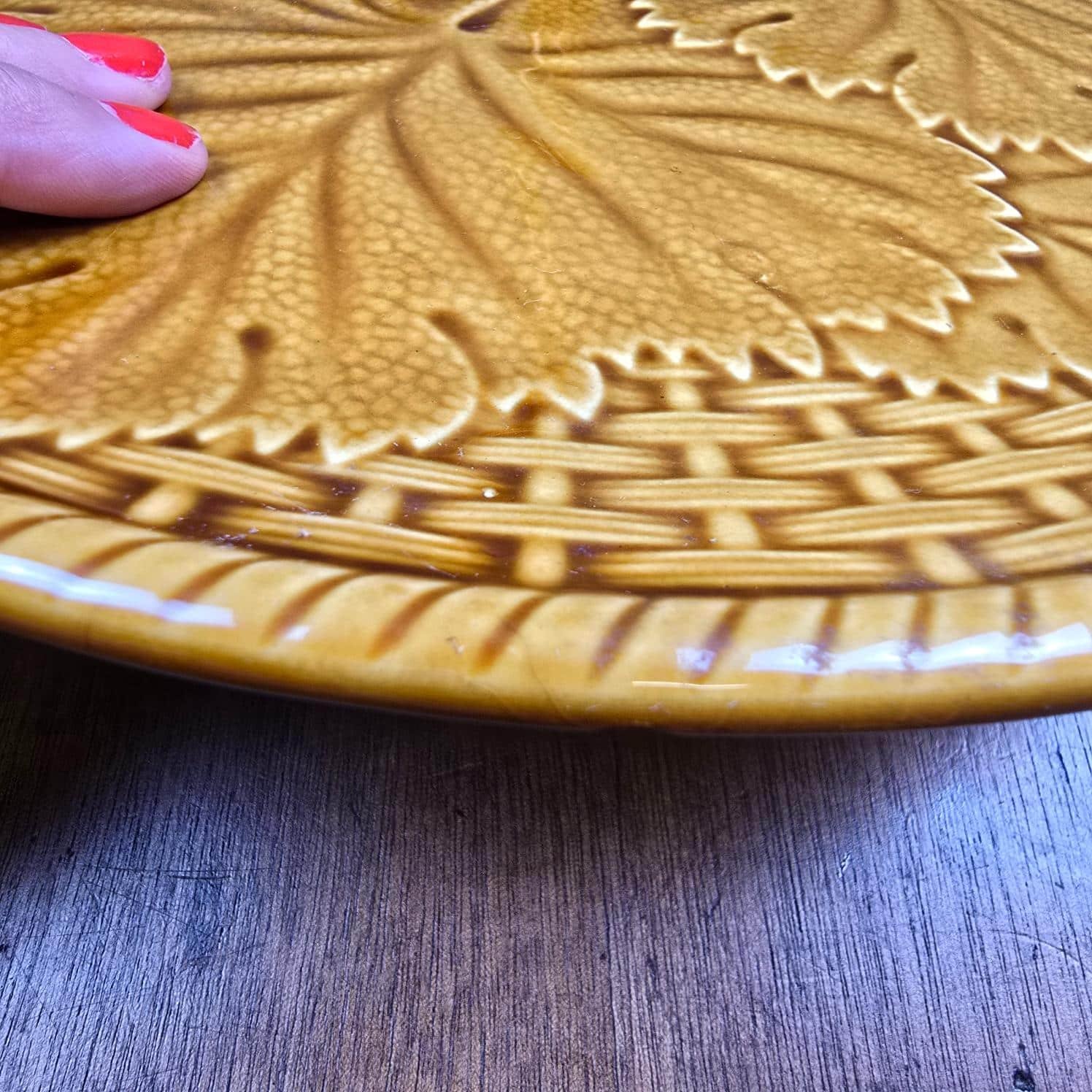 Gros plan du décor de feuilles de vigne en relief sur le présentoir à fromage Gien