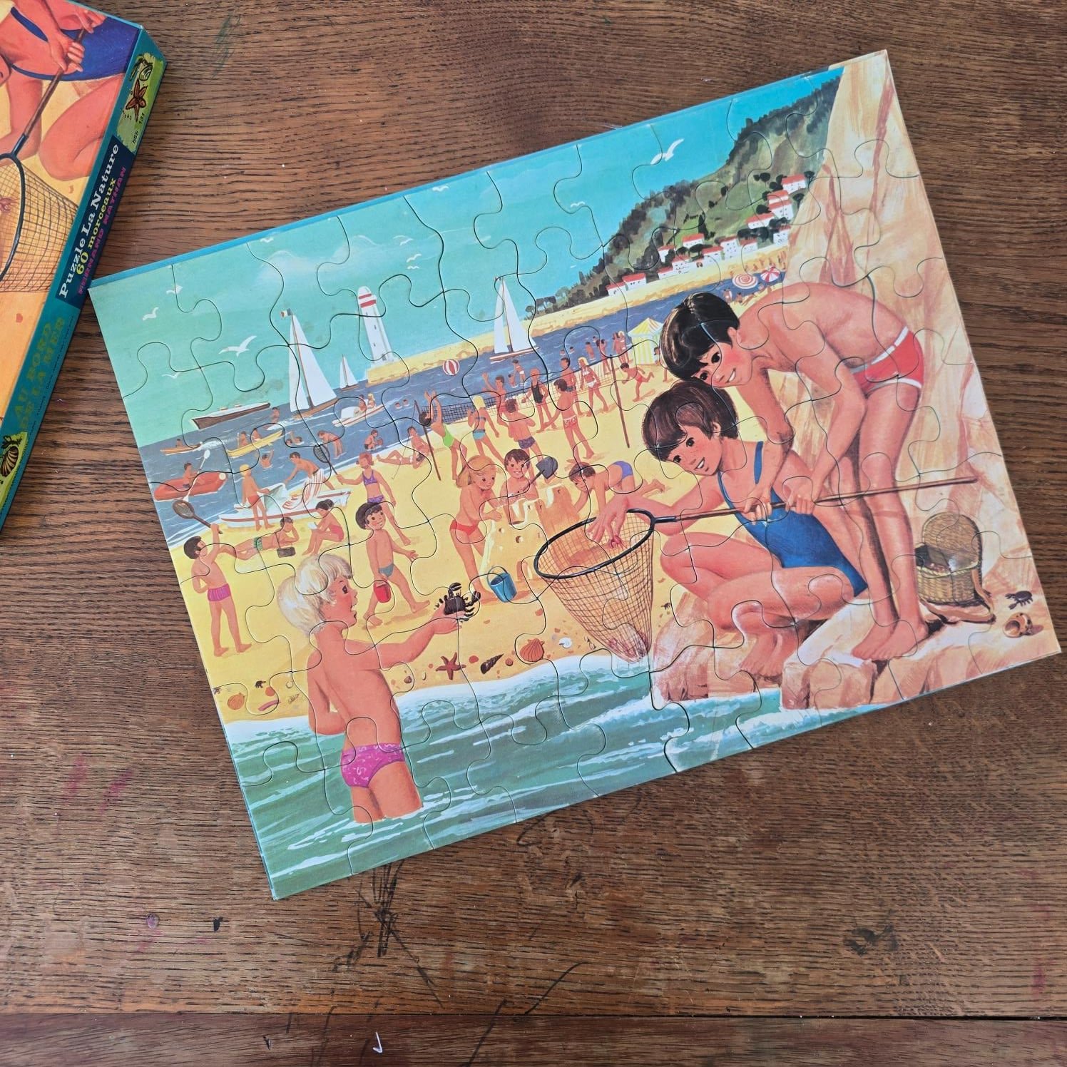 Couvercle illustré du puzzle Au bord de la mer Fernand Nathan, scène de plage
