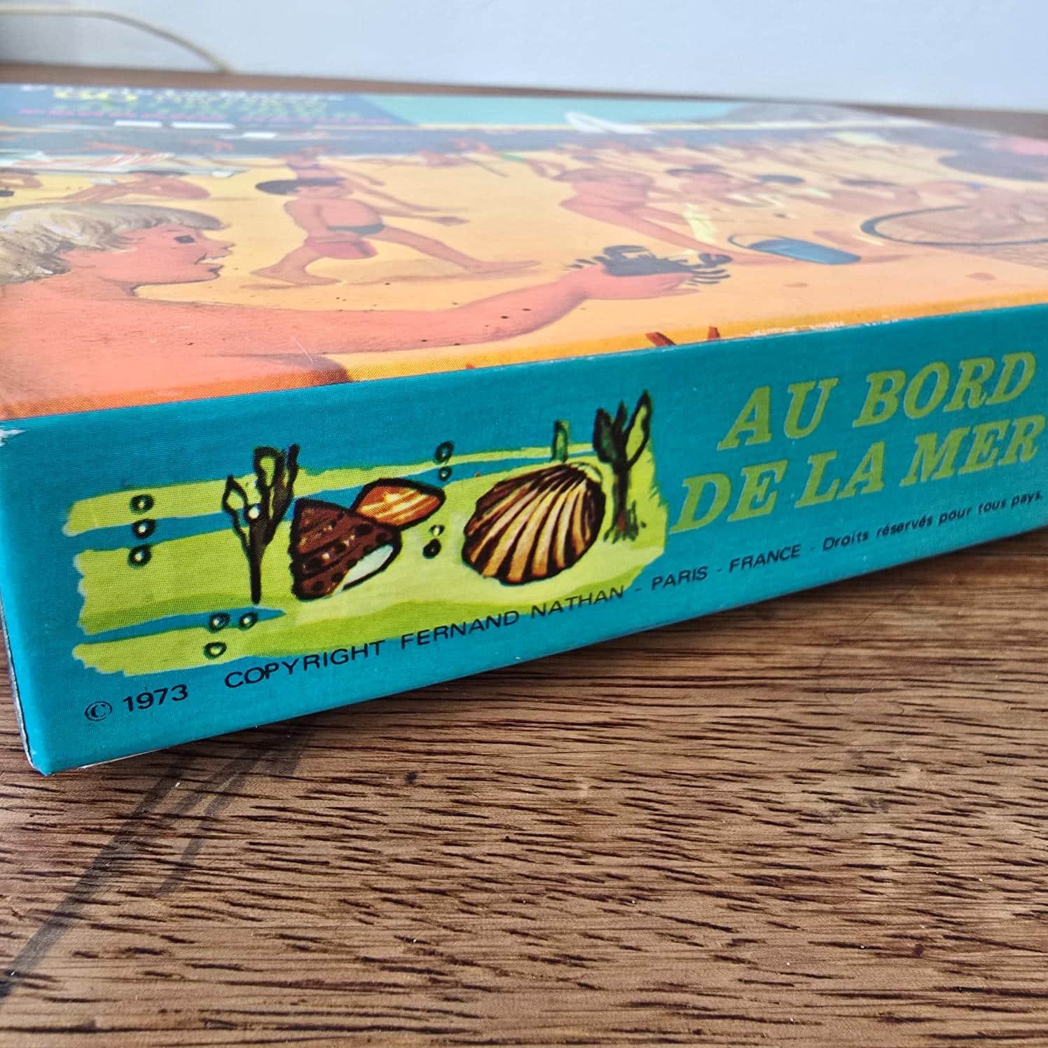 Tranche de la boîte du puzzle Fernand Nathan Au bord de la mer, décor de coquillages