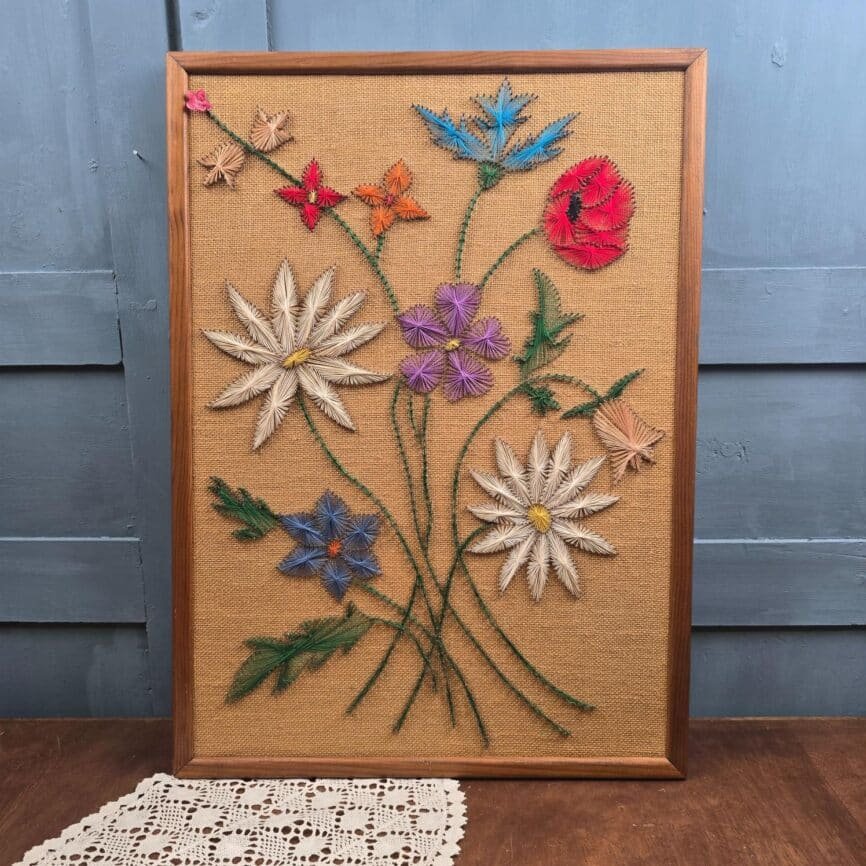 Vue d’ensemble du tableau floral vintage en fils tendus, cadre en bois et bouquet multicolore