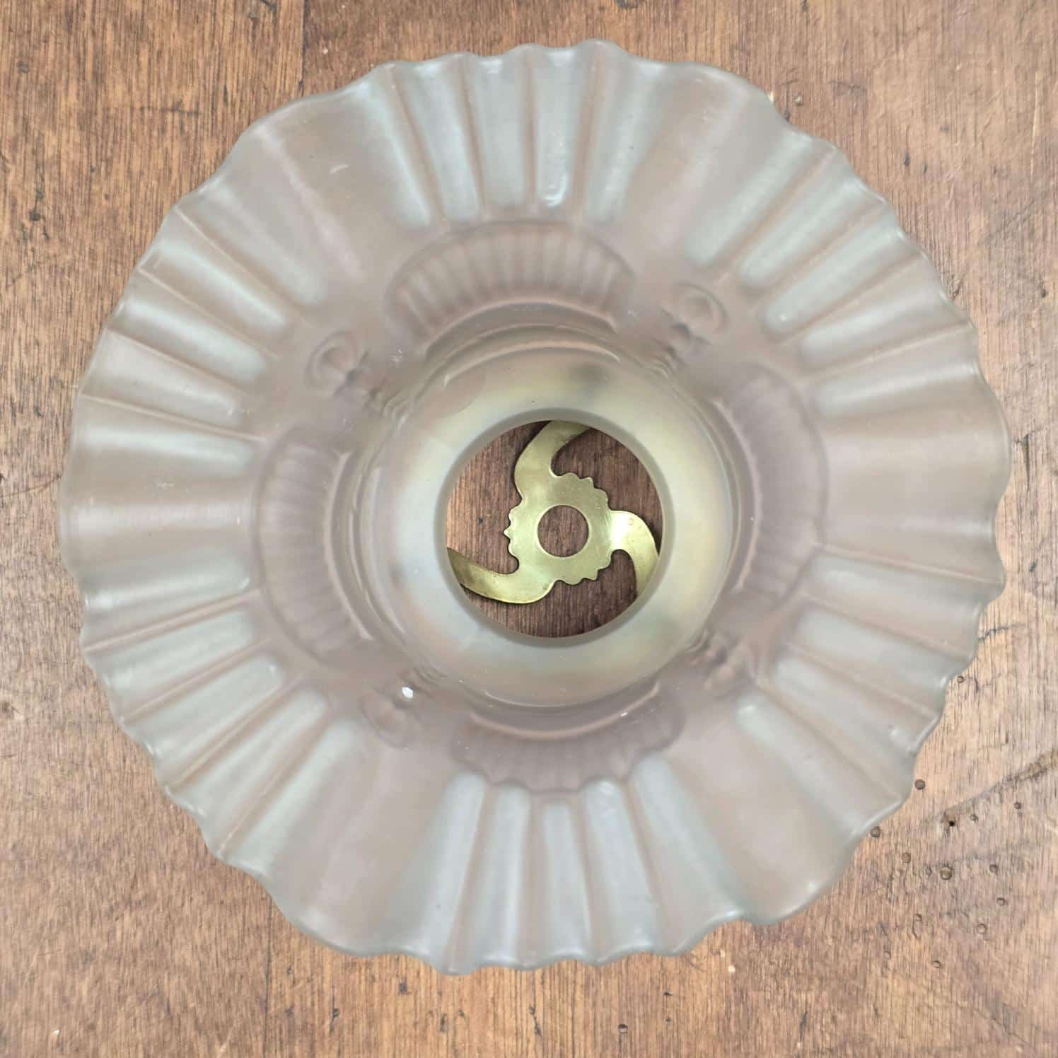 Dessous de la tulipe ancienne montrant le verre moulé plissé et l'ouverture centrale
