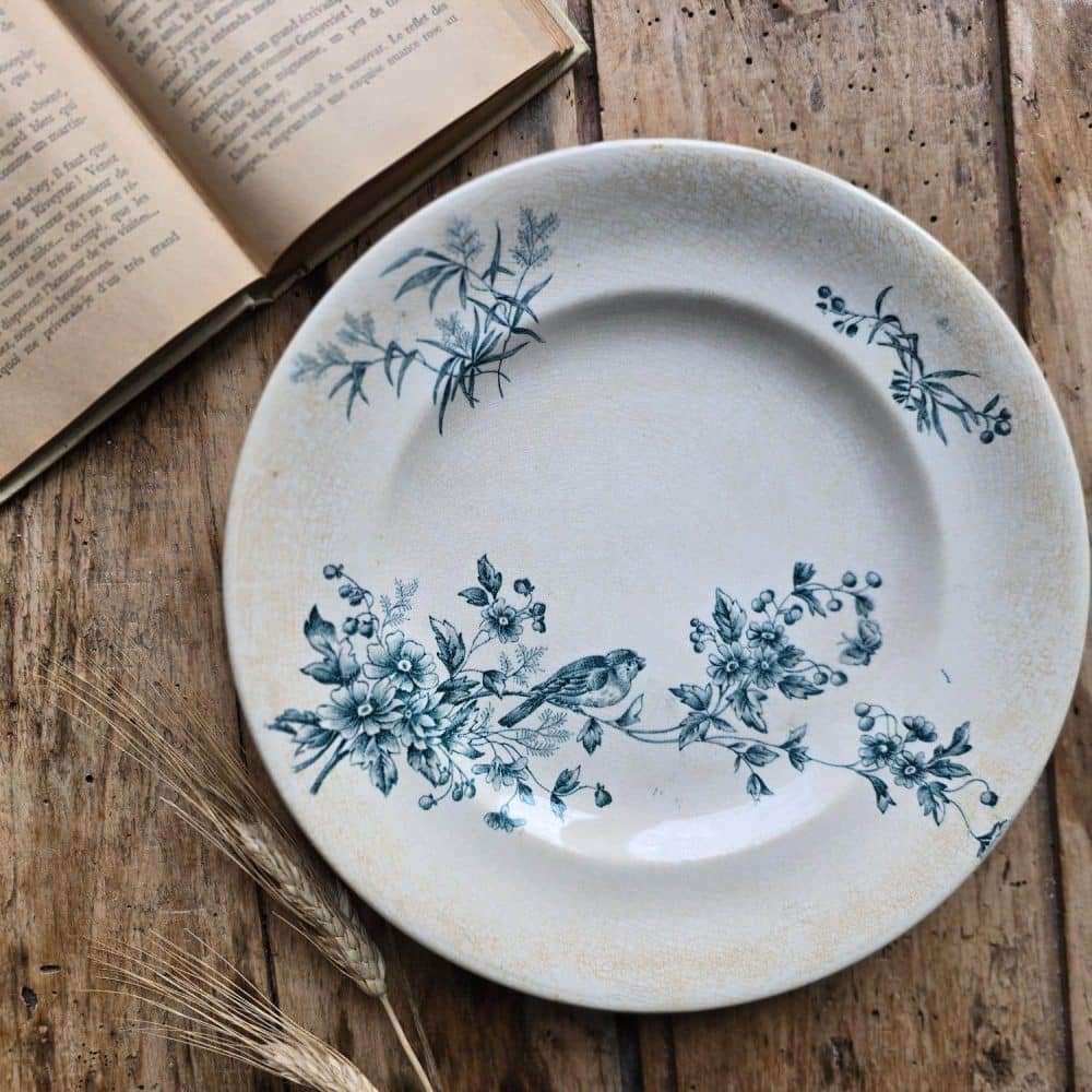 Assiette ancienne Longwy modèle MIGNON en terre de fer, décor floral bleu avec oiseau.