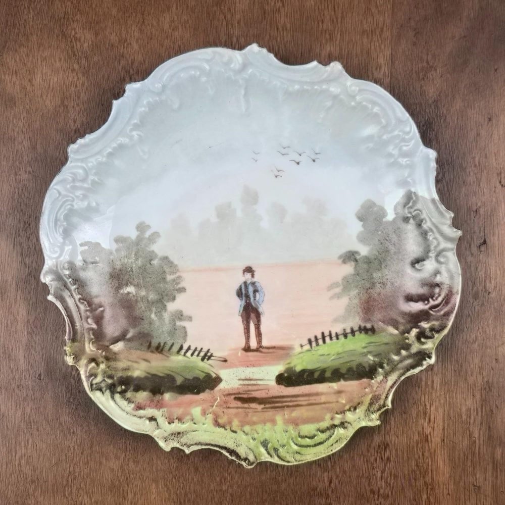 Assiette décorative ancienne Limoges – Scène champêtre peinte main, sur table en bois, vue de dessus