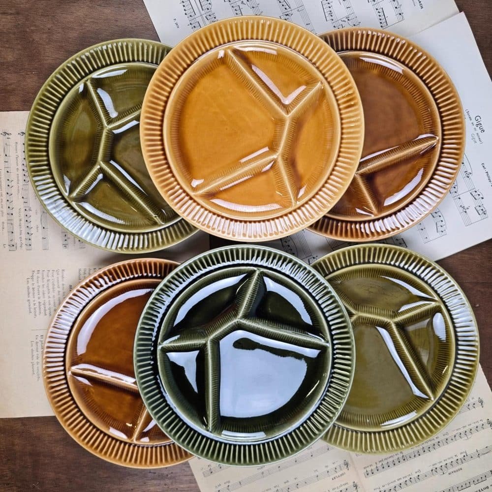 Ensemble complet des six assiettes à fondue Sarreguemines sur table en bois, ambiance rétro et conviviale.