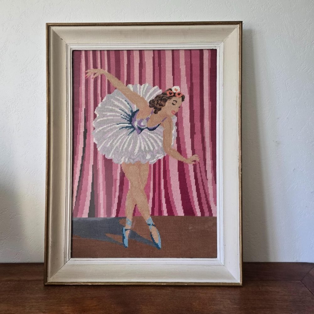Grand cadre vintage avec point de croix représentant une danseuse en mouvement sur fond rose et violet