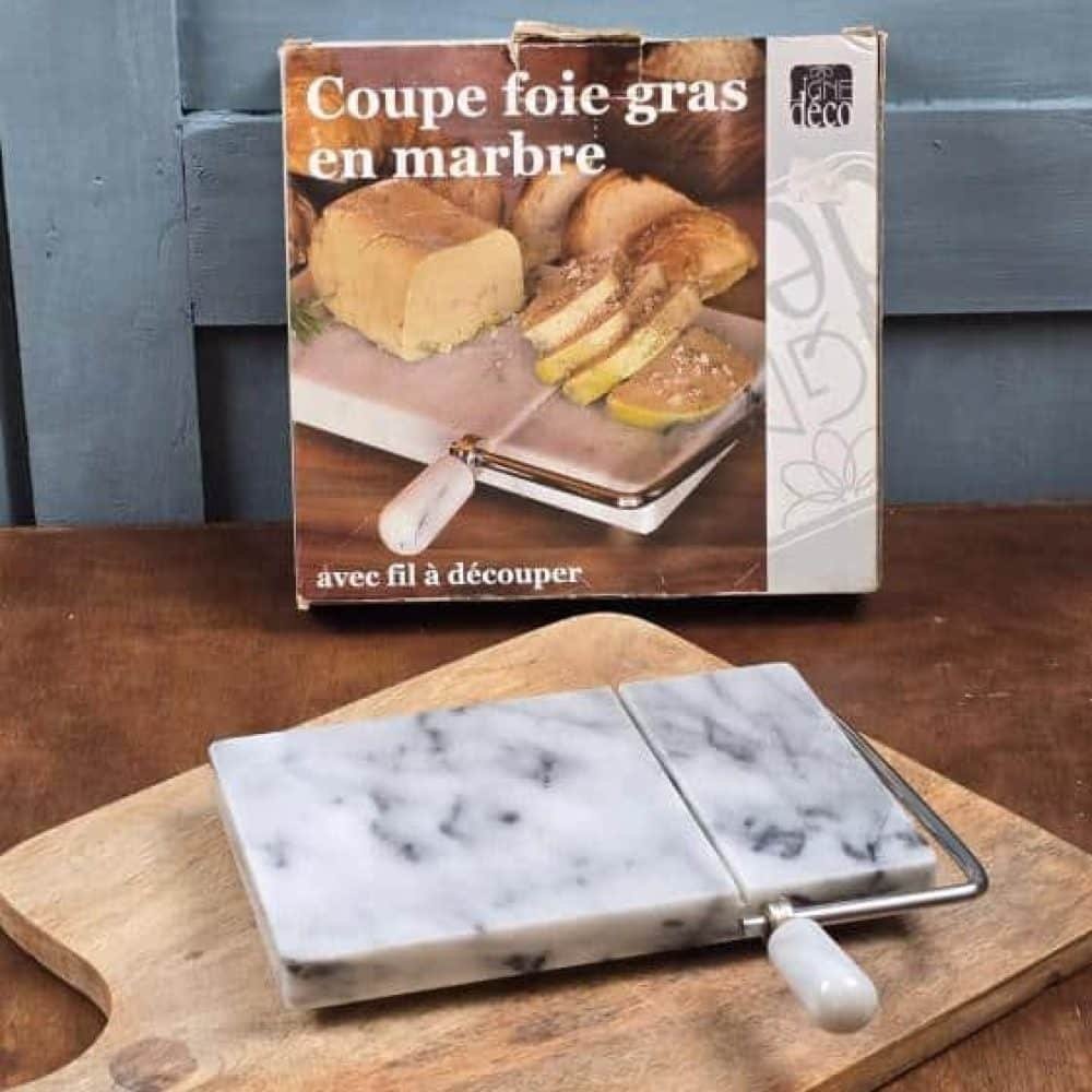 Vue rapprochée du coupe foie gras en marbre et de sa boîte vintage.